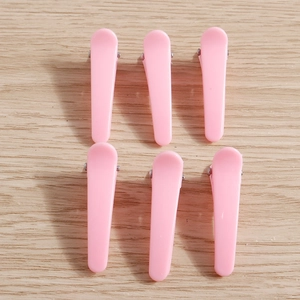 Set of 6 glossy light pink duckbill hair clips displayed on a natural wooden surface
