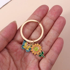 Golden keychain with colorful enamel butterfly and vibrant sunflower pendant charms