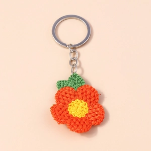 Vue détaillée montrant la texture d'un porte-clés fleur au crochet fait main avec anneau métal