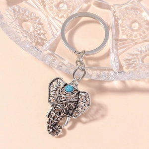 Macro view of vintage silver elephant keychain with turquoise gemstone and hollow design