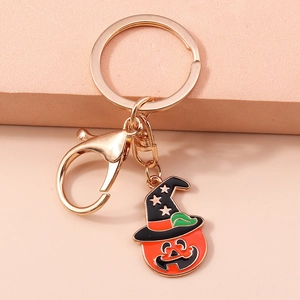 Halloween pumpkin head with witch hat keychain on a pink textured background