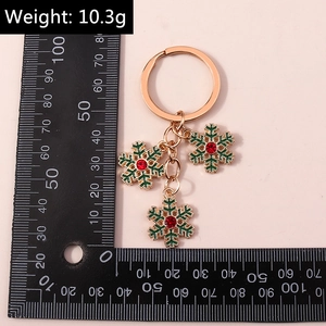 Détail du porte-clés flocon de neige festif avec émail vert et cristal rouge brillant