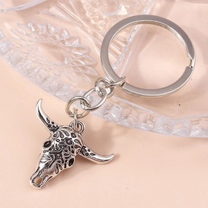 Close-up of vintage bull head keychain with detailed floral engravings in silver finish