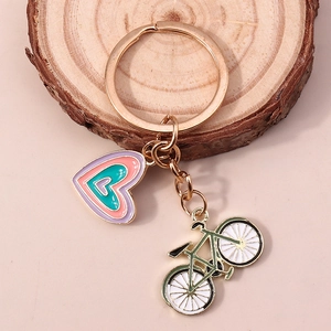 Porte-clés chic en alliage avec cœur et vélo en émail sur un support en bois naturel