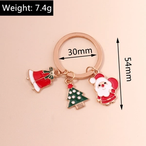 Détails des breloques Père Noël, sapin et clochette sur un porte-clés en métal or rose