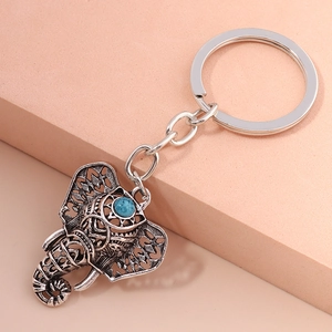 Macro detail of vintage silver elephant keychain with blue turquoise stone and engraving