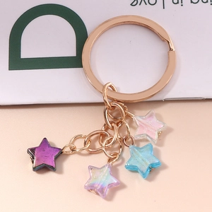 Porte-clés tendance en or rose avec quatre étoiles en résine irisées roses et bleues