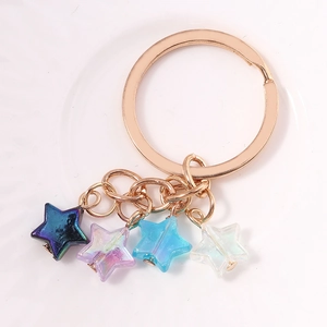 Vue macro des pendentifs étoiles colorés avec anneau en métal or rose pour porte-clés