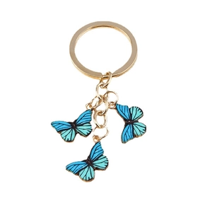 Porte-clés papillon tendance avec pendentifs en émail bleu et vert sur un anneau doré