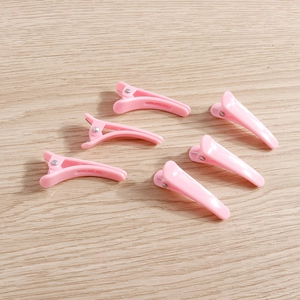 Set of 6 glossy light pink duckbill hair clips on light wood background for daily styling