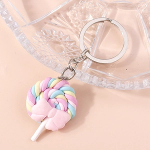 Macro detail of a colorful macaron lollipop keychain with a pink bow and silver metal ring