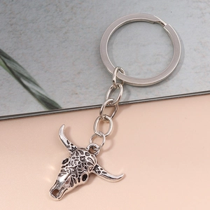 Close-up of vintage silver bull head keychain with intricate carved texture and punk style