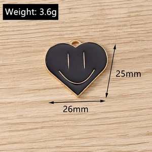 Detail view of heart smile charm with dimensions 25x26mm and weight 3.6g on wood background