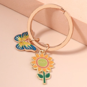 Macro view of rose gold keychain with colorful enamel butterfly and sunflower charms