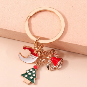 Détail macro du porte-clés de Noël avec pendentifs émaillés de lune, sapin et clochette