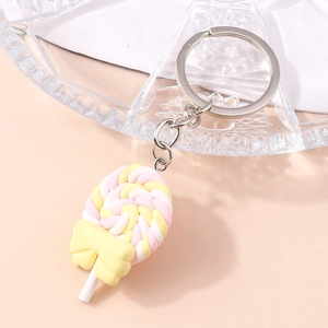 Macro shot of pink and yellow swirl lollipop keychain with a bright yellow bow accent