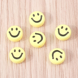 Dettaglio delle perline gialle con faccina sorridente per braccialetti e gioielli fai da te