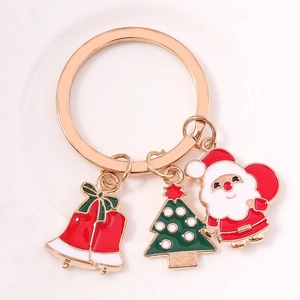 Détail d'un porte-clés de Noël avec père Noël, cloche et sapin sur un anneau doré