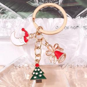 Détail d'un porte-clés de Noël avec sapin émaillé et clochette rouge sur alliage doré