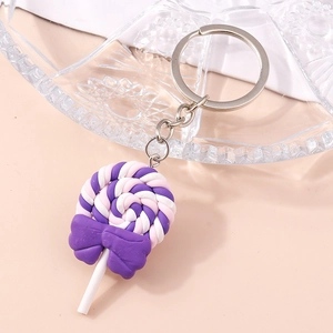 Detailed close-up of a tricolor lollipop keychain with a purple bow and silver ring