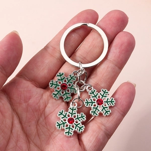 Détail du porte-clés flocon de neige en métal avec émail vert et strass rouges brillants