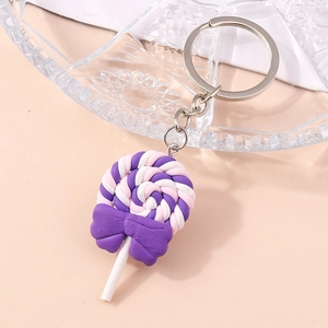 Macro view of a colorful spiral lollipop keychain with a purple bow and silver metal chain