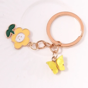 Detailed view of sunflower and butterfly charms on a rose gold keychain ring