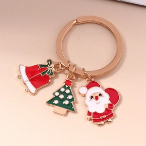 Détail d'un porte-clés de Noël avec charmes émaillés Père Noël, sapin et clochette