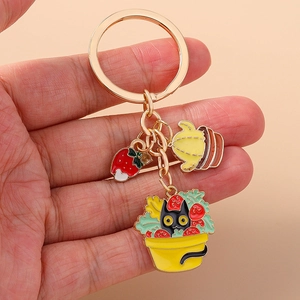 Close-up of alloy keychain featuring a cute black cat in strawberry pot and cactus charm