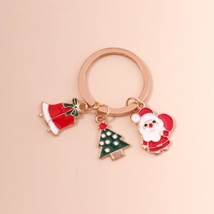 Détail d'un porte-clés de Noël avec des breloques de Père Noël et d'arbre vert