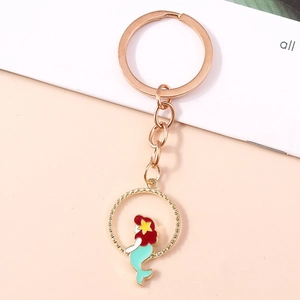 Dettaglio portachiavi sirena con capelli rossi e coda turchese su anello oro rosa