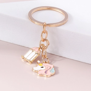 Détail d'un porte-clés licorne dorée avec breloque lanterne rose et blanc sur support