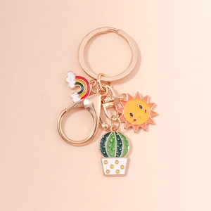 Detail of colorful rainbow sun and cactus charms on a golden alloy keychain ring