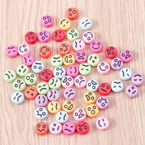 Vista macro di perline emoji colorate in plastica con varie espressioni per gioielli fai-da-te