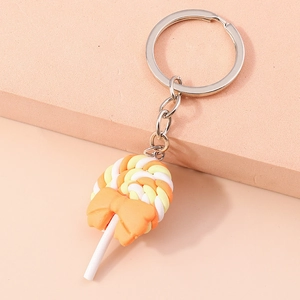 Detail of a colorful swirl lollipop keychain with an orange bow and silver metal ring