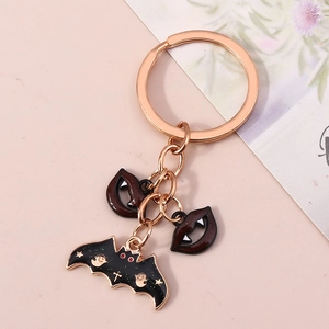 Détail d'un porte-clés Halloween or rose avec pendentifs chauve-souris et lèvres de vampire