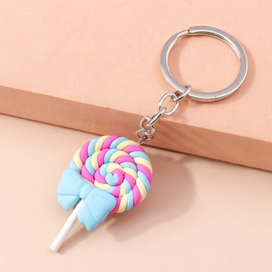 Macro detail of a colorful spiral lollipop keychain with a blue bow on a pink stand
