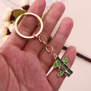 Détail du porte-clés en métal en forme de bambou avec feuilles en émail vert