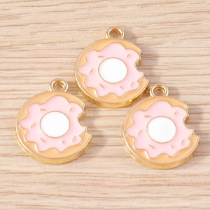 Macro detail of donut charms with pink enamel and gold metal frames for DIY jewelry