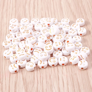 Dettaglio di perline a forma di sorriso in acrilico bianco con motivi emoji dorati DIY