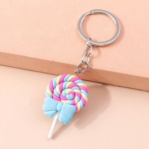 Close-up of a colorful spiral lollipop keychain with a blue bow on pink podiums