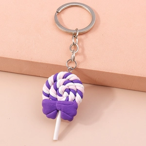 Close-up of a purple spiral lollipop keychain with a dark purple bow and silver ring