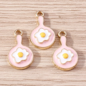 Close-up of three fried egg pan alloy charms with pink enamel for DIY jewelry making