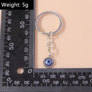 Mesure détaillée d'un porte-clés vintage Evil Eye avec une chaîne en métal argenté