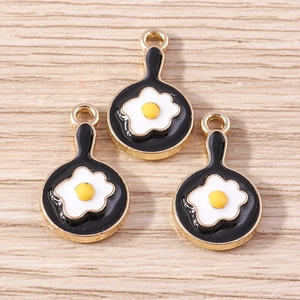 Close-up of three cute fried egg pan alloy charms with gold plating for DIY jewelry