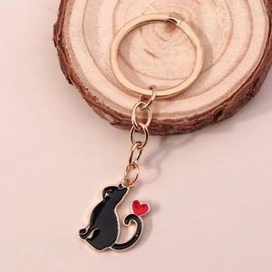 Porte-clés chat noir mignon avec cœur rouge et anneau doré sur support en bois