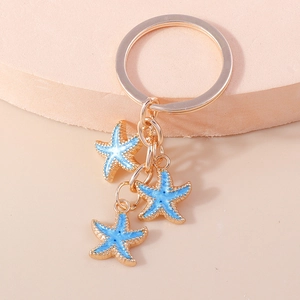 Porte-clés doré avec trois pendentifs d'étoile de mer bleus au style océanique