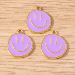 Detailed close-up of purple alloy smiley face pendants with gold trim for DIY jewelry making