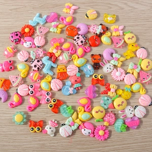 Flat lay of colorful resin charms including flowers and animals for DIY craft projects