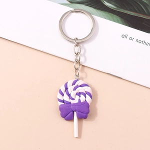 Detailed view of a purple and white spiral lollipop keychain with a bow and metal ring